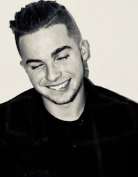 a black and white photo of a young man smiling